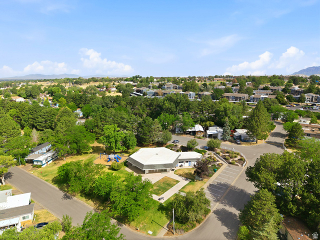 2875 North Hill Field Road, Unit 62 Layton, UT 84041 - Photo 33 of 34 Aerial perspective showcasing a residential community with abundant mature trees and mountainous terrain in the distance