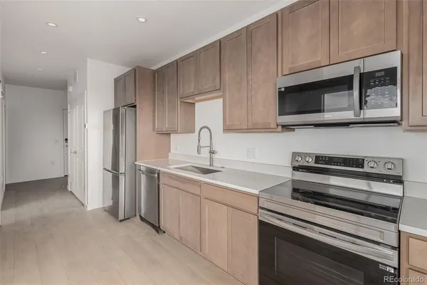 a kitchen with stainless steel appliances a stove microwave and sink
