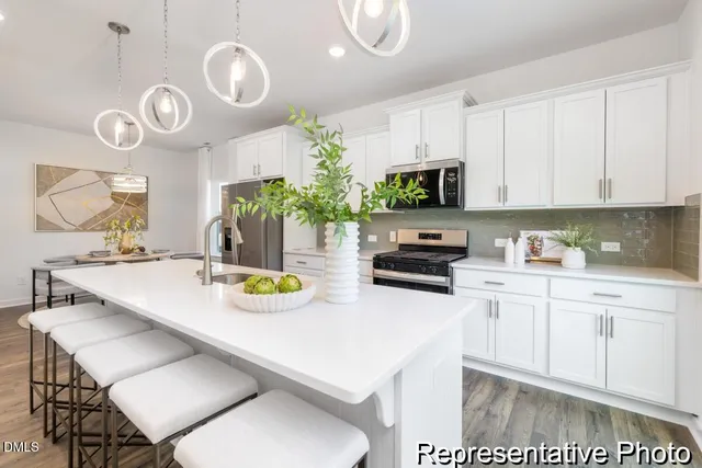a kitchen with a sink a stove and chairs