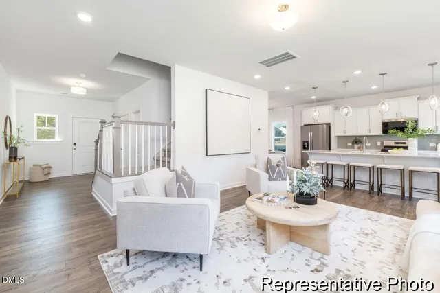 a living room with furniture a table and kitchen view