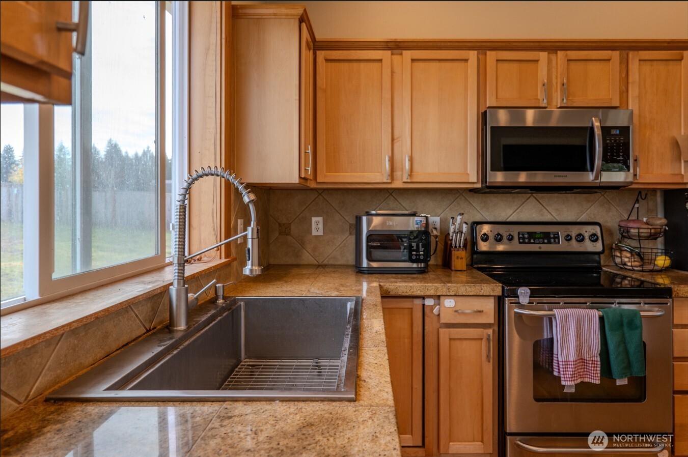 9723 Phillips Road Southeast Port Orchard, WA 98367 - Photo 7 of 37 a kitchen with stainless steel appliances granite countertop a stove a sink and a microwave