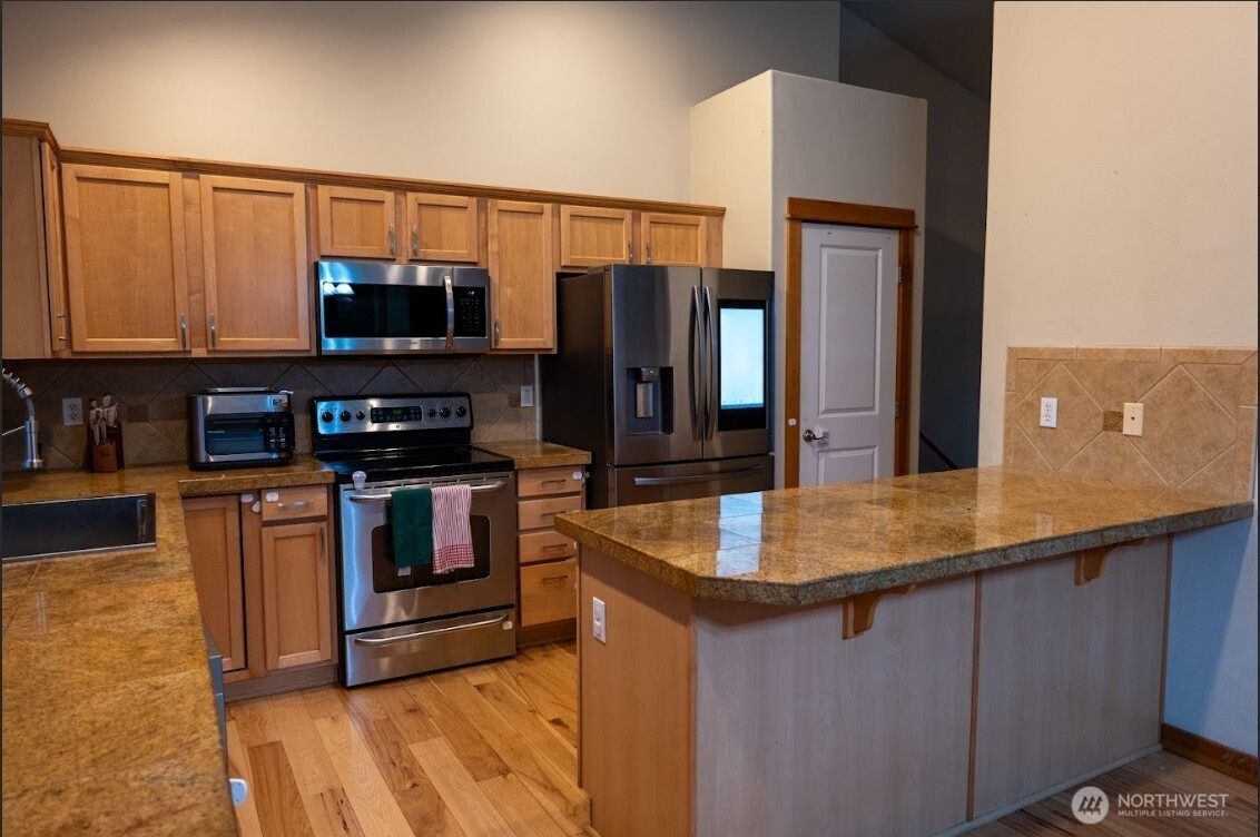 9723 Phillips Road Southeast Port Orchard, WA 98367 - Photo 8 of 37 a kitchen with stainless steel appliances granite countertop a sink and a refrigerator