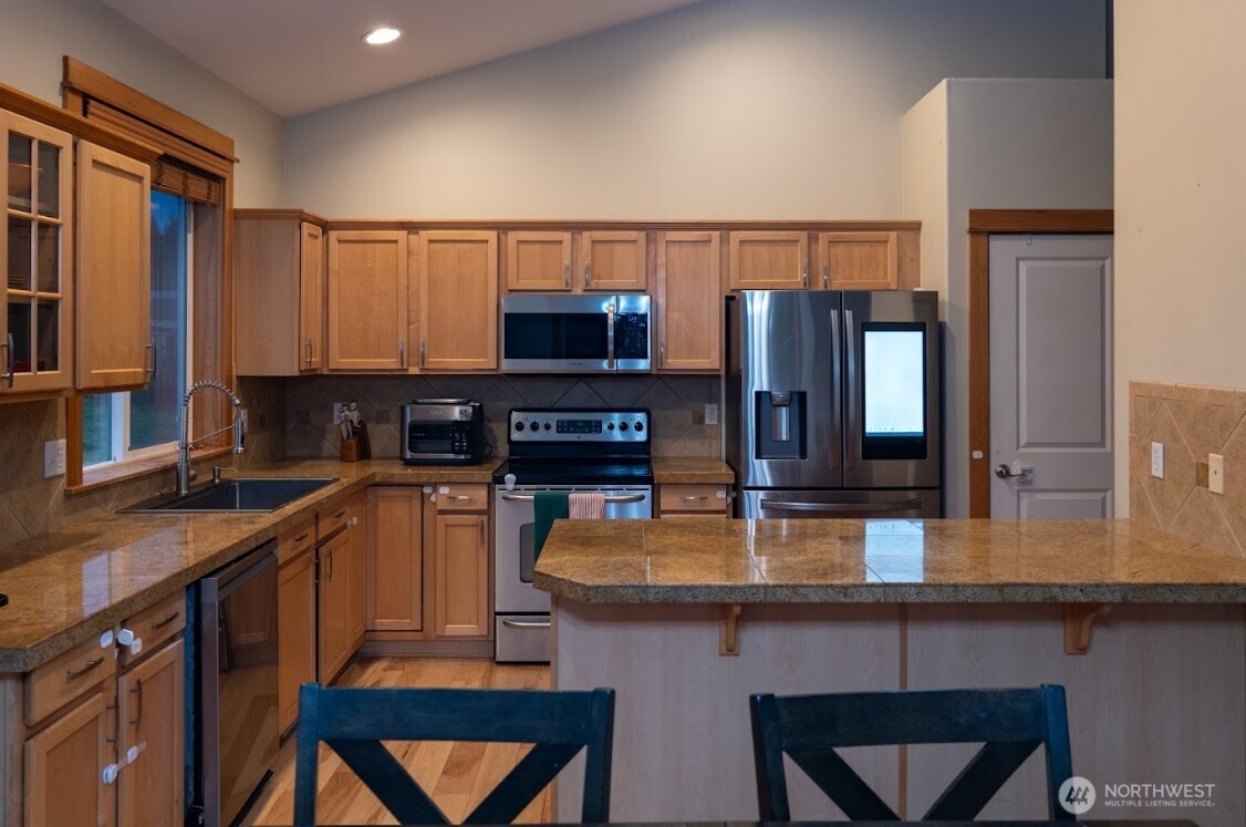 9723 Phillips Road Southeast Port Orchard, WA 98367 - Photo 9 of 37 a kitchen with stainless steel appliances granite countertop a sink and a refrigerator