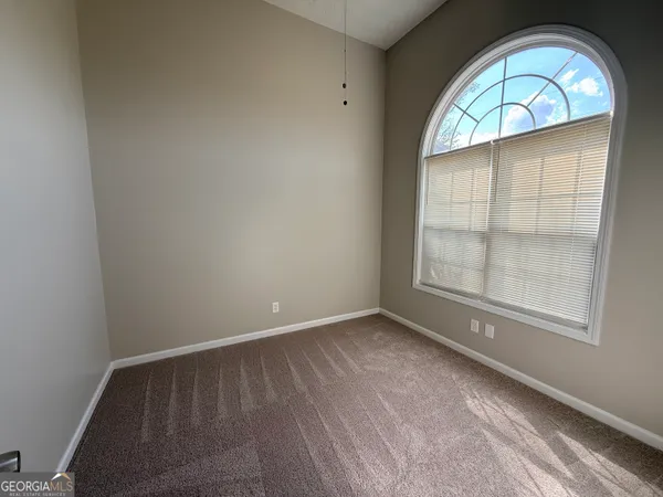 an empty room with windows and closet
