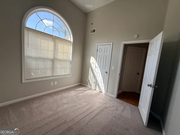 a view of a house with a yard and large trees