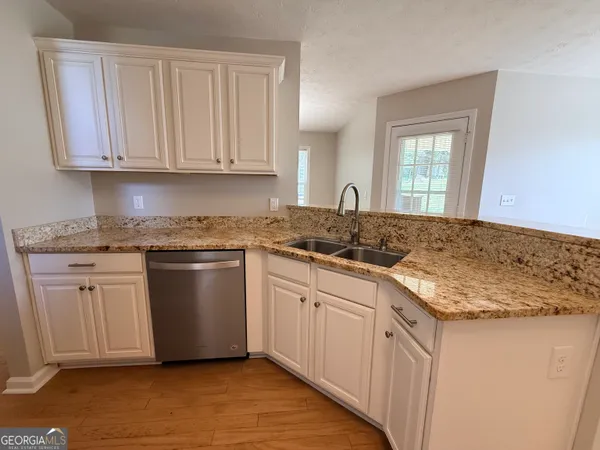 a kitchen with a refrigerator a stove top oven and white cabinets