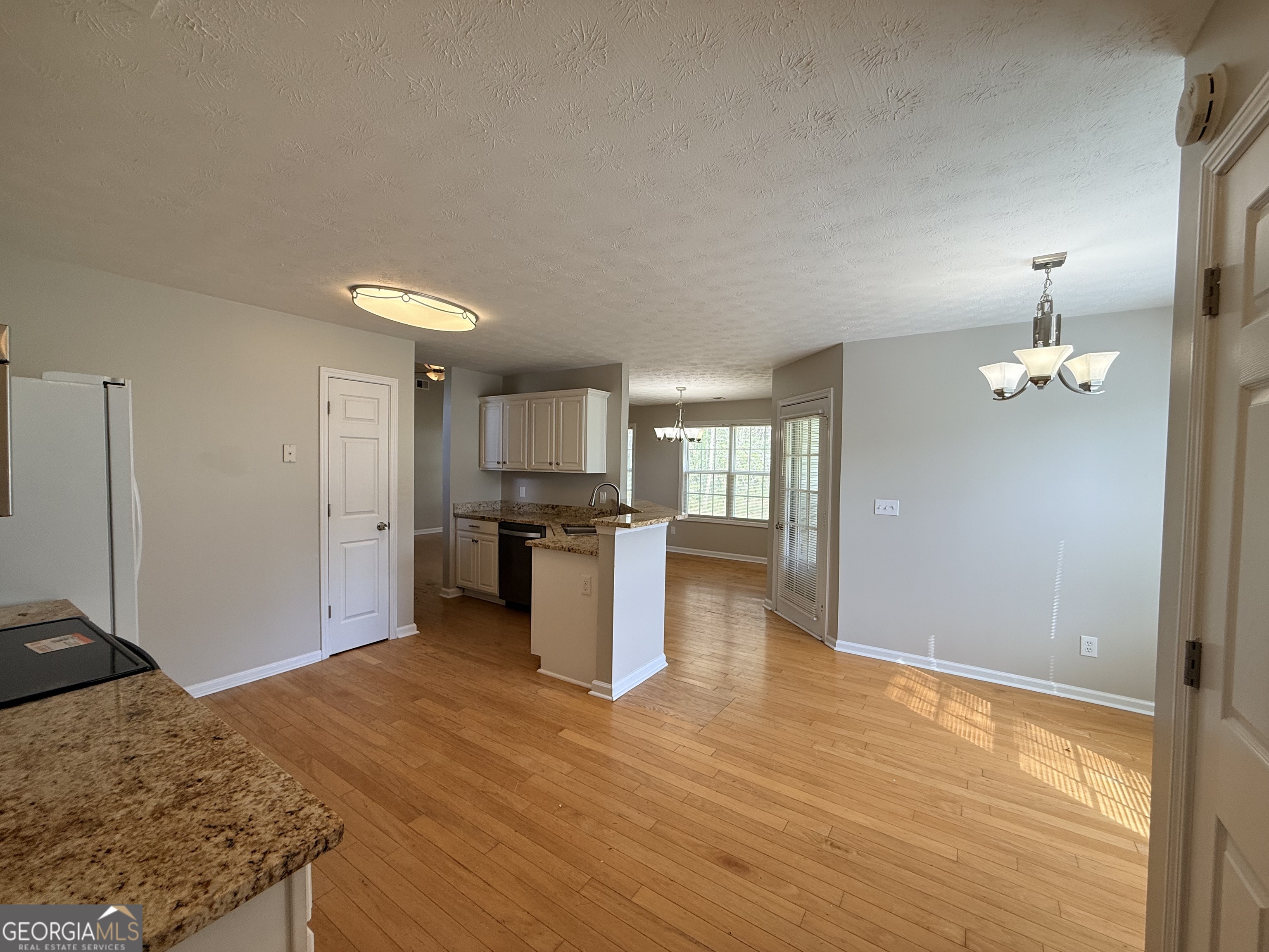 577 Pendergrass Road Winder, GA 30680 - Photo 7 of 25 a view of kitchen and empty room with wooden floor