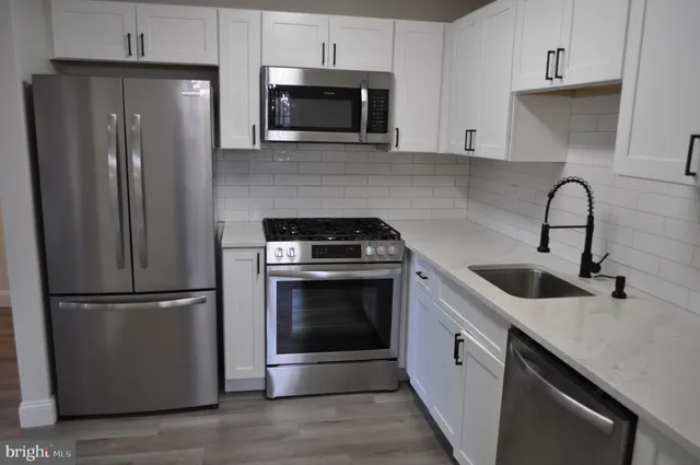 a kitchen with stainless steel appliances granite countertop a refrigerator sink and microwave