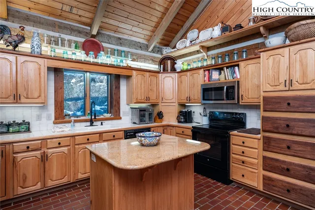 a kitchen with stainless steel appliances granite countertop a sink a stove and cabinets