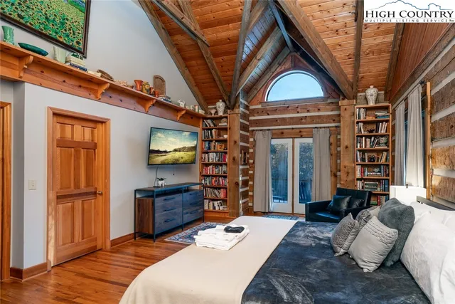 a bedroom with a bed dresser and a large window