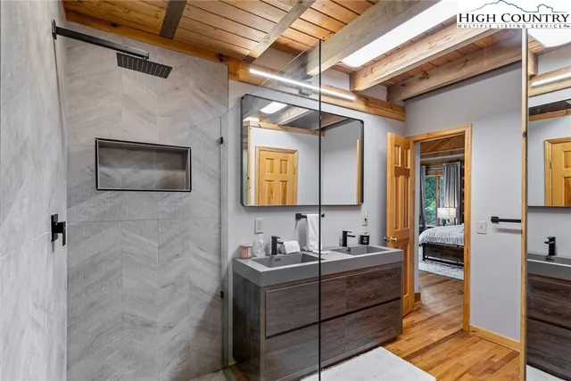 a bathroom with a sink mirror and a shower