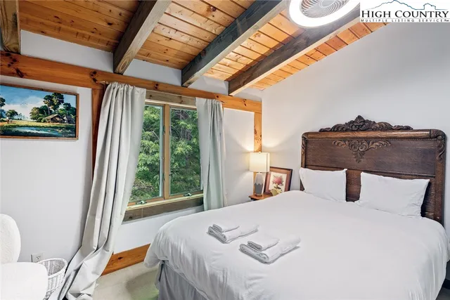 a bedroom with a bed and a large window