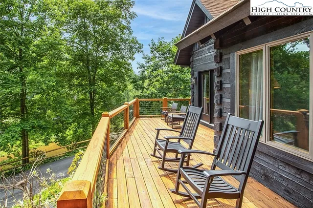 a view of a backyard with wooden floor and a two large trees