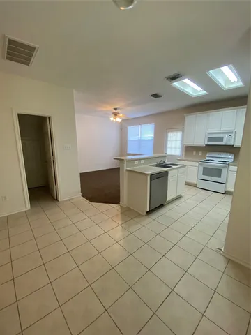 a kitchen with stainless steel appliances a stove a sink and a refrigerator