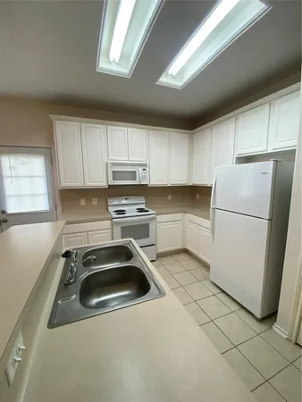 a kitchen with a refrigerator sink and cabinets