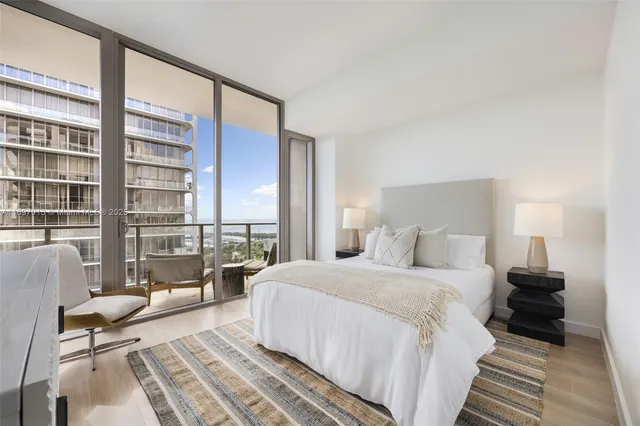 a bedroom with a bed and a large window with outer view