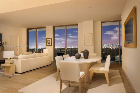 a dining room with furniture and a large window