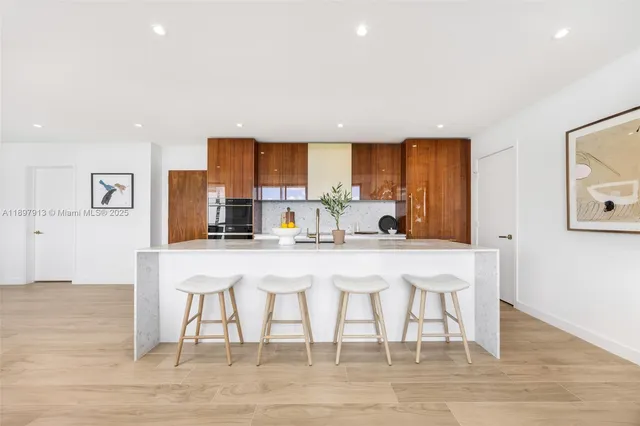 a kitchen with a dining table chairs and wooden floor