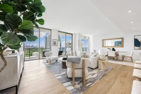 a living room with furniture a large window with wooden floor