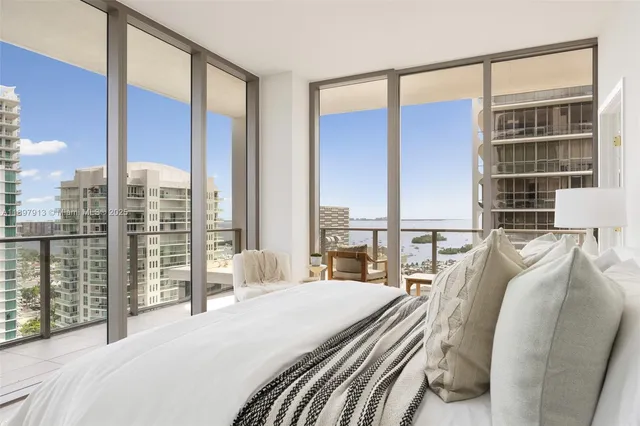 a bedroom with a large window and a bed