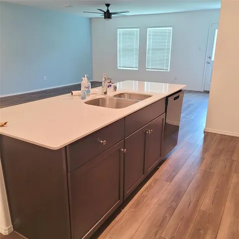 a bathroom with a sink a mirror and wooden floor