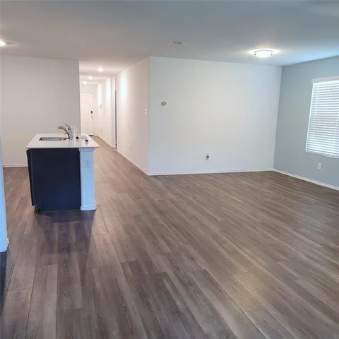 a view of a room with wooden floor and window