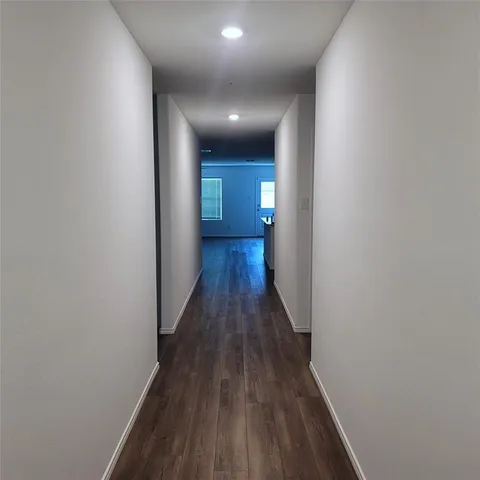 a view of a hallway with wooden floor