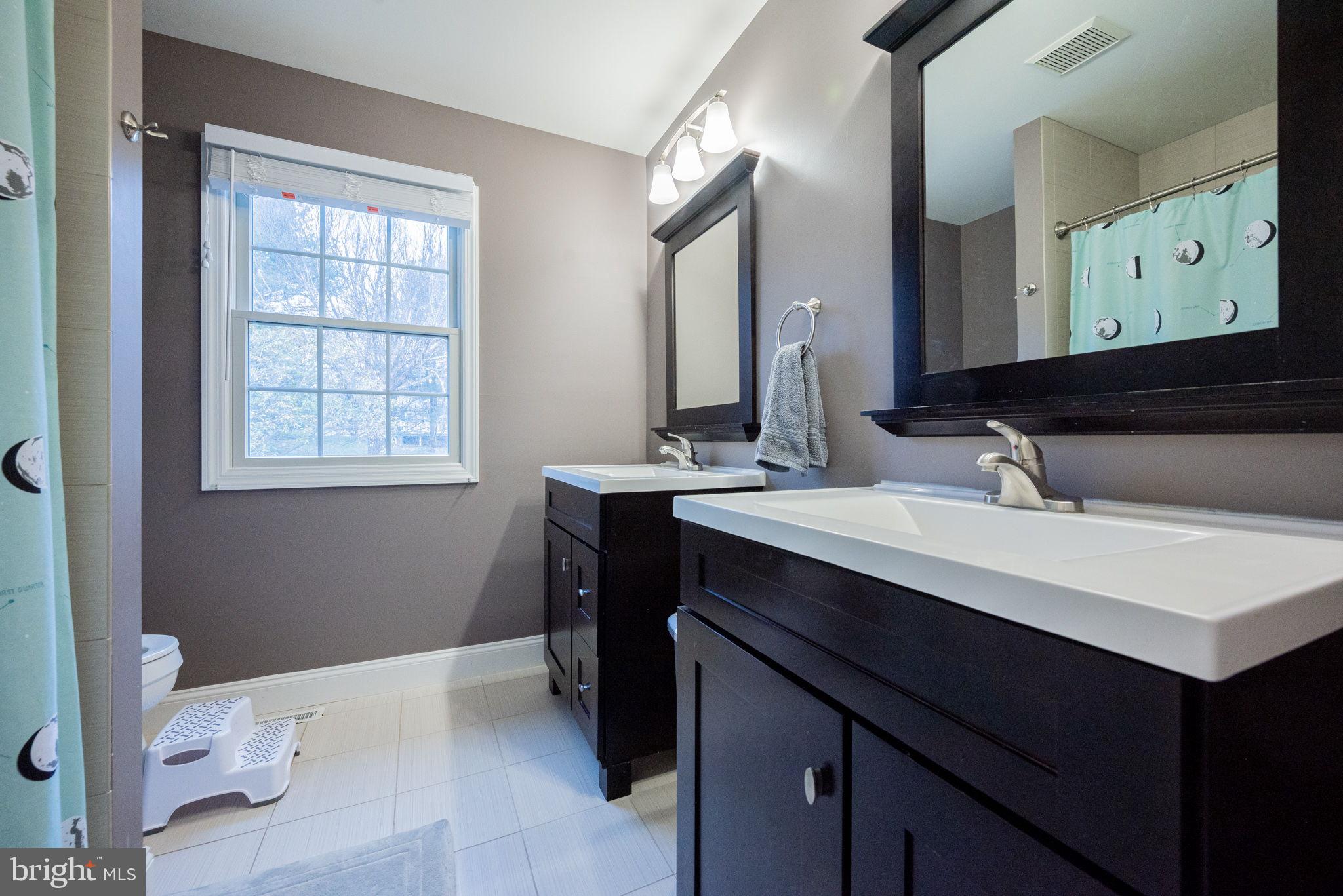 34 Raphael Road Hockessin, DE 19707 - Photo 36 of 60 a bathroom with a sink vanity and a mirror