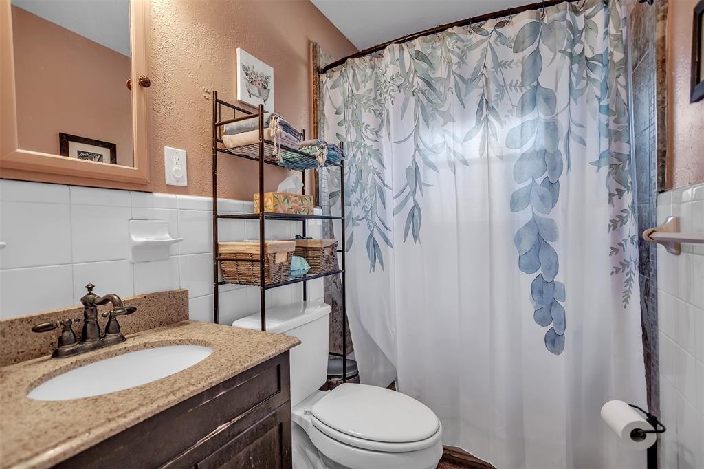 709 Hurstview Drive Hurst, TX 76053 - Photo 12 of 28 a bathroom with a granite countertop sink toilet and shower
