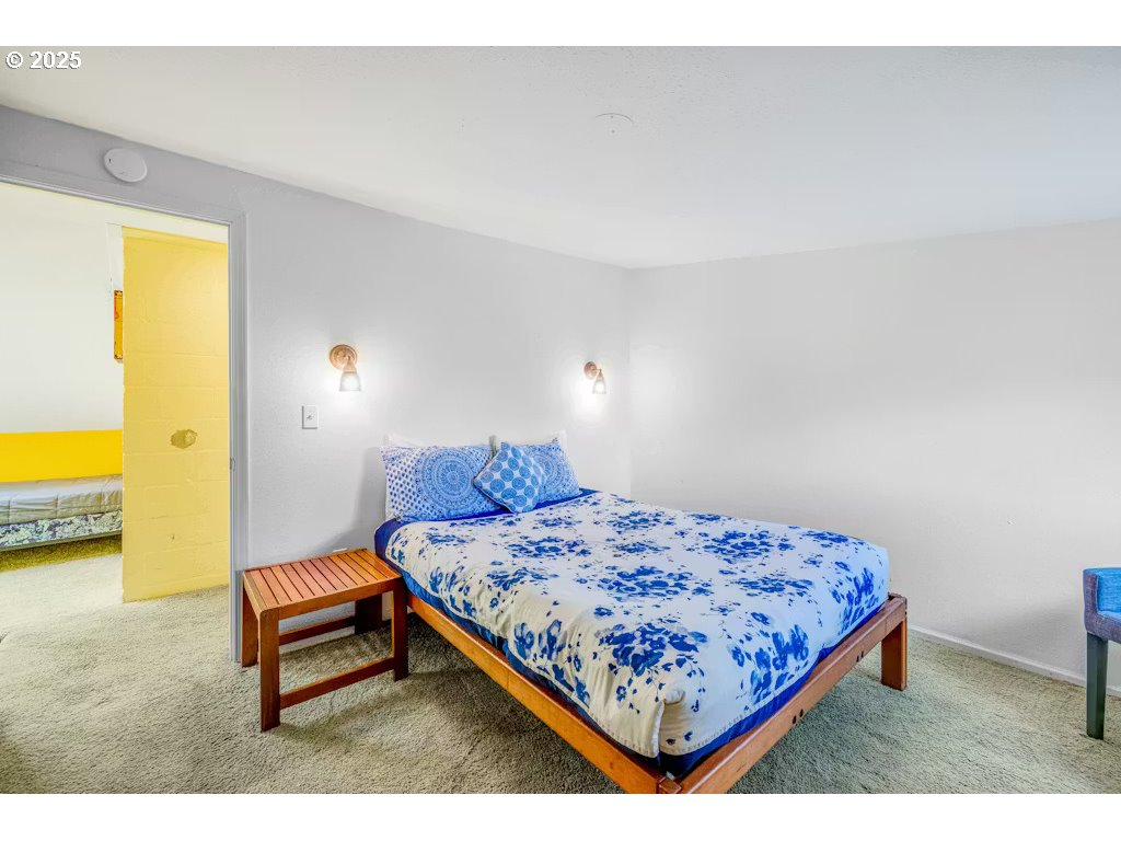 25990 Sandlake Road Cloverdale, OR 97112 - Photo 23 of 40 a bedroom with a bed and wall painting