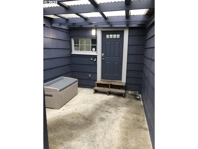a view of a yard with plants and wooden fence