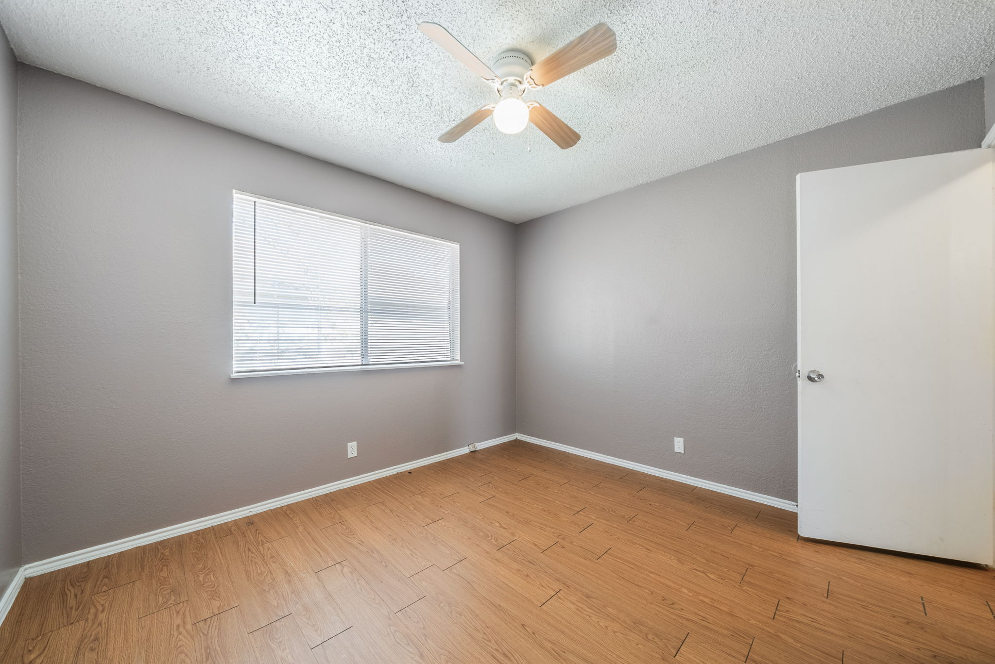 5807 Spring Meadow Road, Unit B Austin, TX 78744 - Photo 25 of 31 Wood-look flooring and a window with blinds define this tranquil sleeping space.
