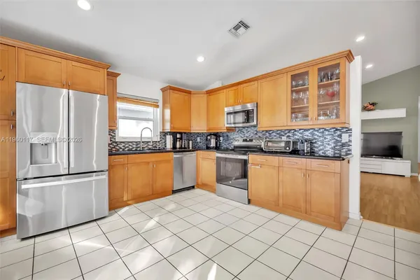 a kitchen with stainless steel appliances granite countertop a refrigerator and a stove top oven