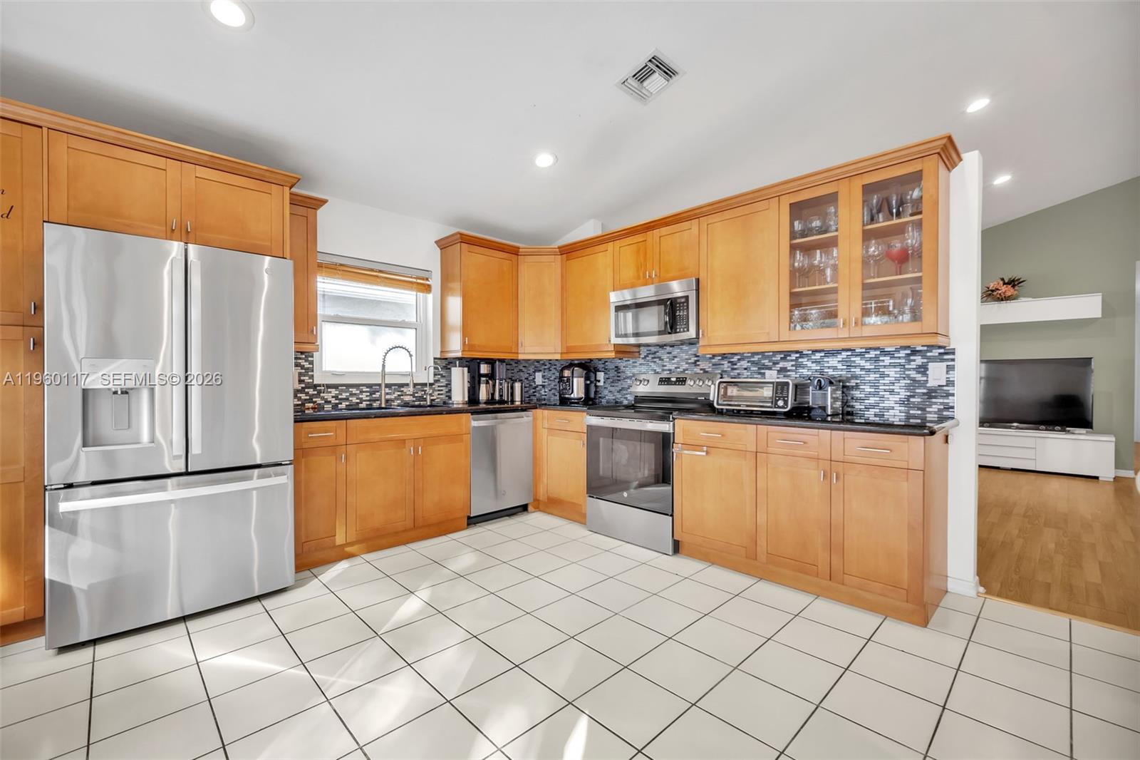 10337 Coventry Court Boca Raton, FL 33428 - Photo 19 of 44 a kitchen with stainless steel appliances granite countertop a refrigerator and a stove top oven