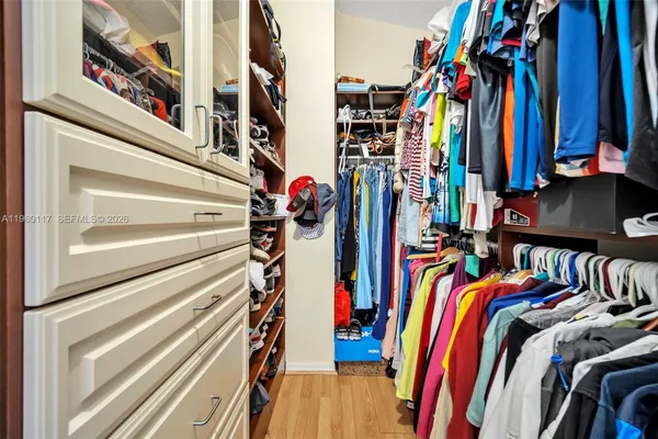 a view of walk in closet with clothes and shoes