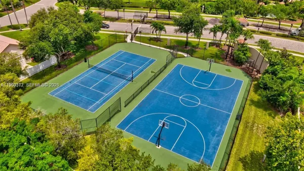 an aerial view of residential houses with outdoor space and trees