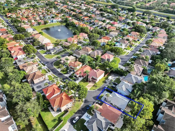 an aerial view of residential houses with outdoor space and trees