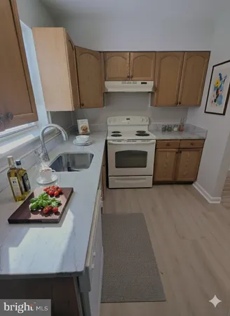 a kitchen with a stove a microwave and wooden floor