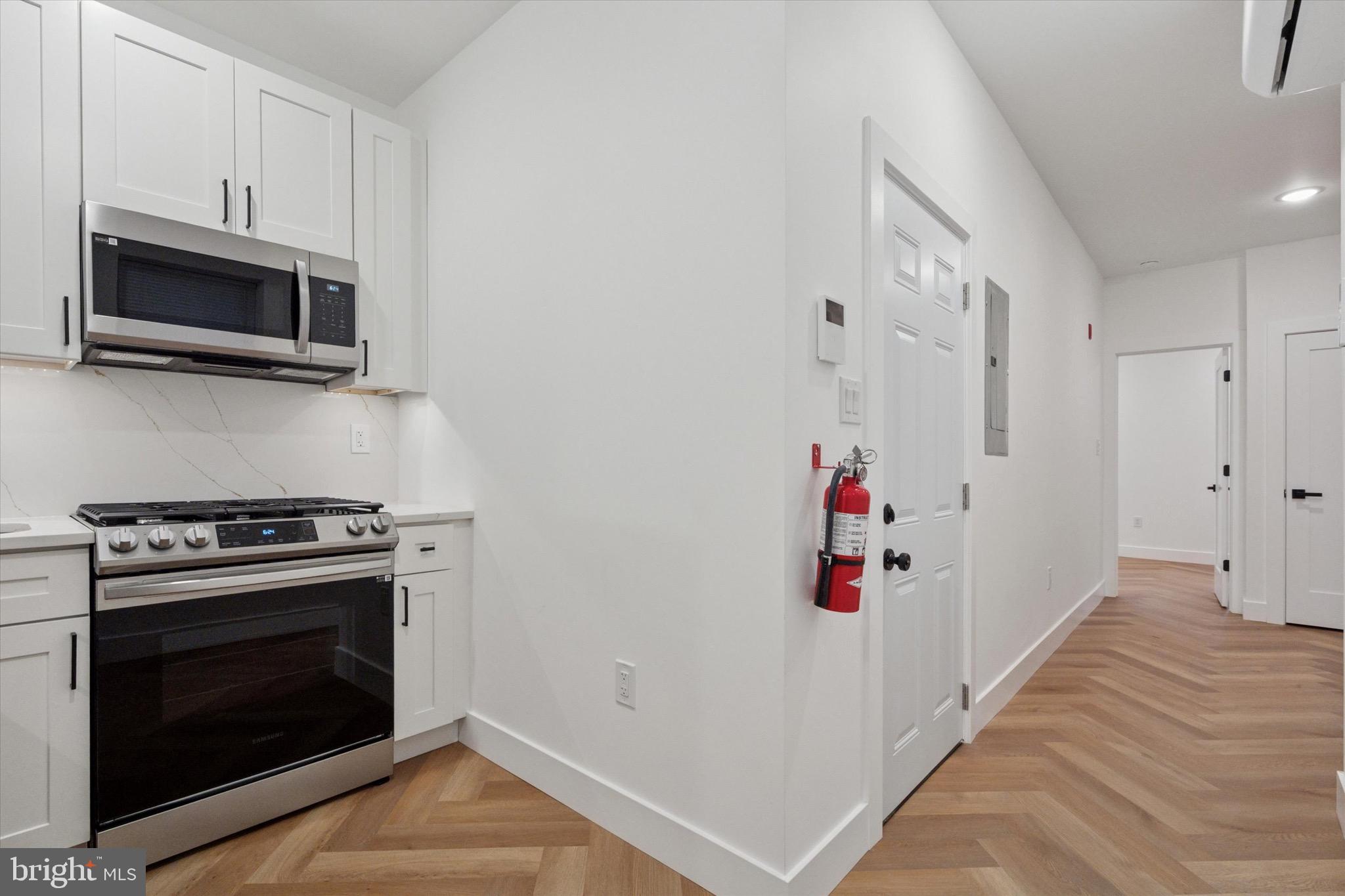 1438 Tasker Street, Unit 2 Philadelphia, PA 19145 - Photo 3 of 11 a view of a kitchen with an empty space and a stove top oven
