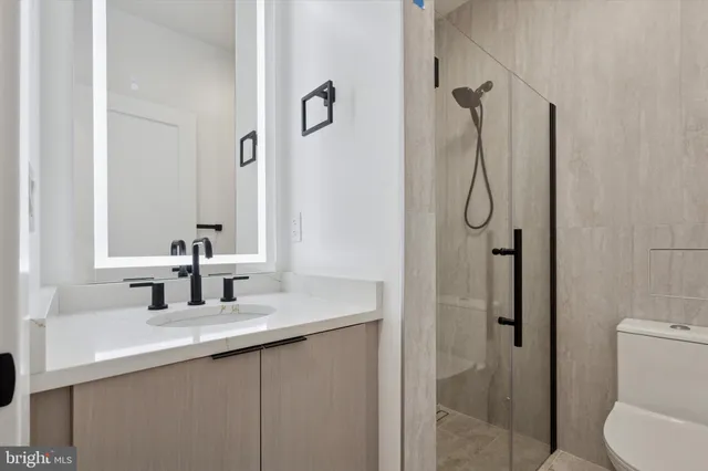 a bathroom with a granite countertop sink toilet and shower