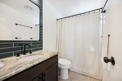 a bathroom with a granite countertop sink toilet and shower