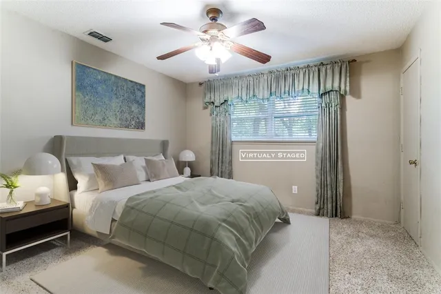 an empty room with chandelier fan and windows