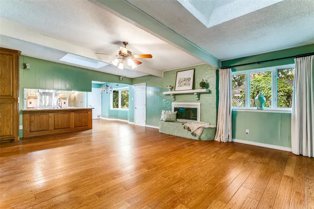 a view of an empty room with window and fire place
