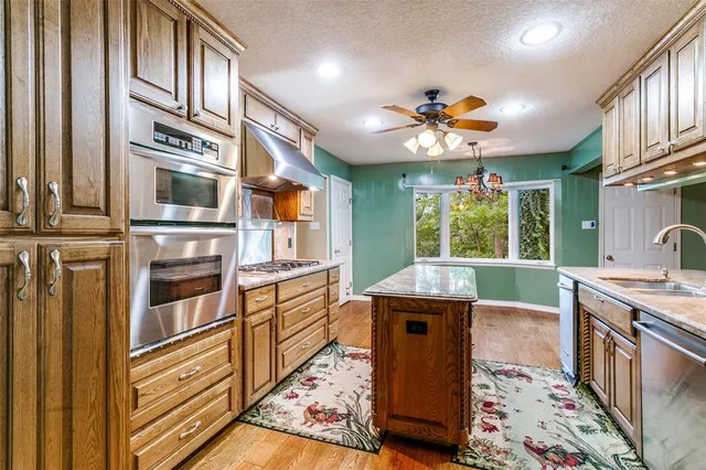 a kitchen with stainless steel appliances granite countertop a stove and a sink