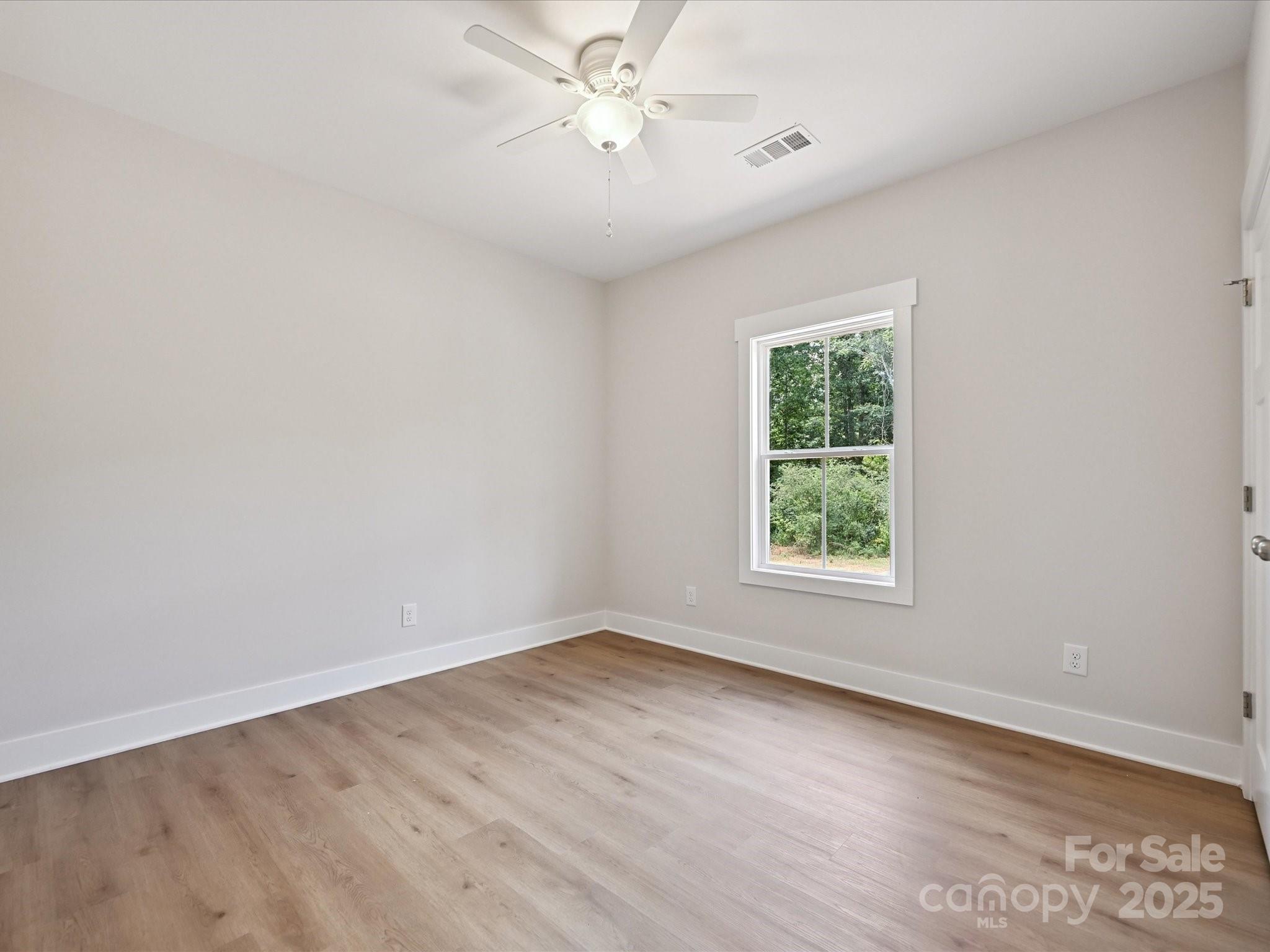 280 Old Pinckney Road York, SC 29745 - Photo 24 of 29 an empty room with wooden floor ceiling fan and windows