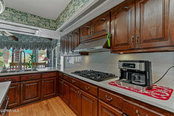 a bathroom with a granite countertop sink a mirror and a wooden floor