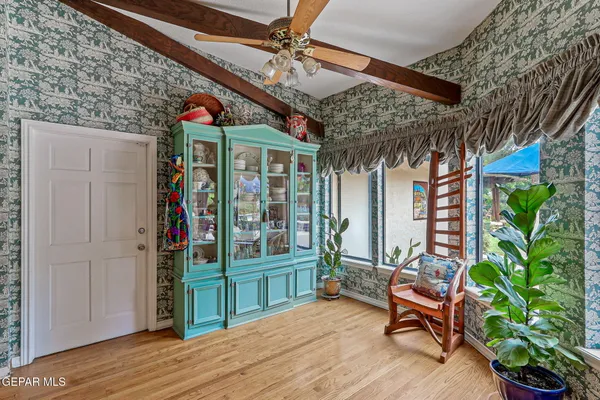 a backyard of a house with table and chairs plants and large tree