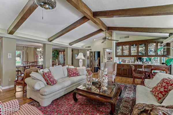 a living room with furniture a flat screen tv and kitchen view