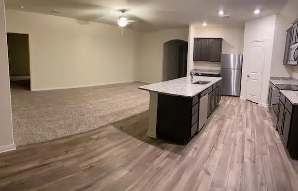 a kitchen that has a sink a stove and a wooden floor