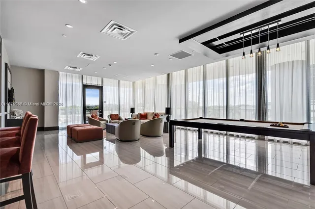a living room with furniture a large window and chairs